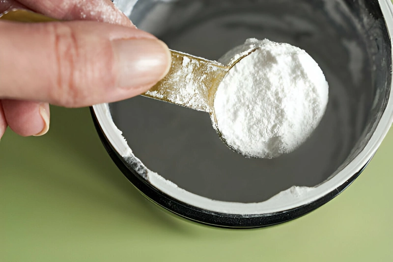 scoop de suplemento de glutamina en polvo en un envase