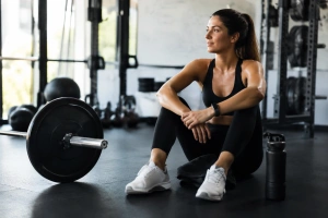 Chica joven descansando en el gimnasio